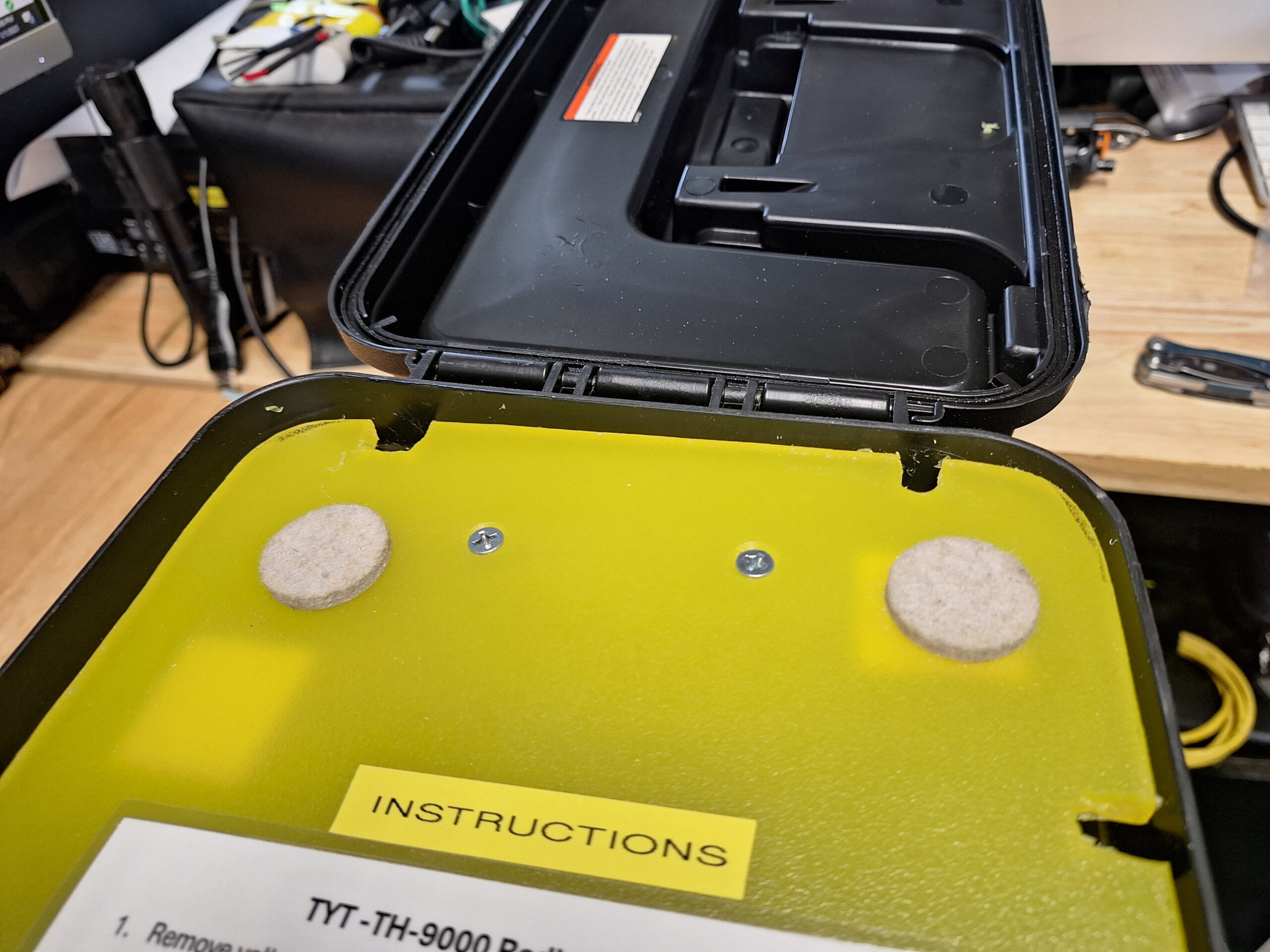 Yellow cutting board with notches cut out for cable pass through.