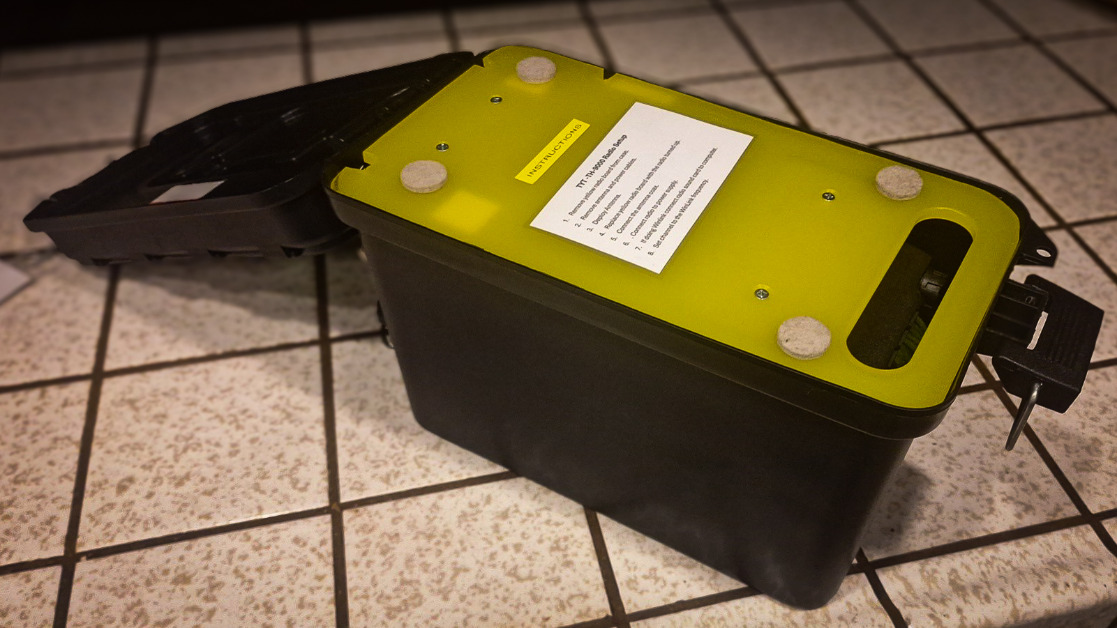 Yellow cutting board fit into the top of a black utility box.